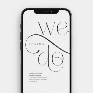 A still image from the animated wedding invitation, showing the "We Do" message formed by delicate black calligraphy on a textured craft paper background.